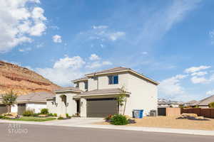 Mediterranean / spanish-style house with stucco siding, an attached garage, driveway, and a mountain view