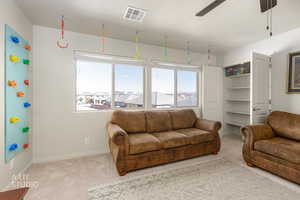 Living room featuring ceiling fan, carpet flooring, and a textured ceiling
