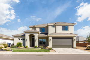 View of front of home with stucco siding, concrete driveway, an attached garage, and a tiled roof
