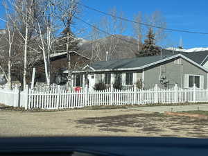 Single story home with a fenced front yard and a mountain view