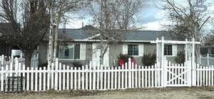 View of front of home with a fenced front yard and a gate