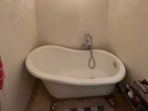 Full bathroom with a freestanding bath and tile patterned flooring