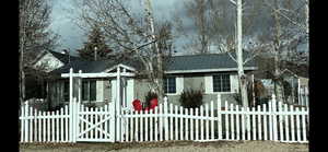View of front facade featuring a metal roof, a gate, a fenced front yard, and a chimney