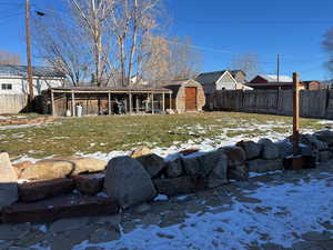 Fenced backyard featuring a storage shed