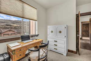 Office space with light carpet and baseboards