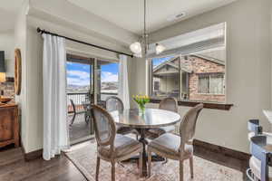 Dining area with wood finished floors and a chandelier