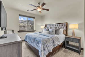 Carpeted bedroom featuring a ceiling fan and baseboards