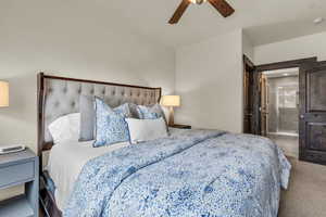 Bedroom with carpet flooring, ensuite bathroom, and a ceiling fan