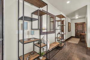 Corridor featuring dark wood-type flooring and baseboards