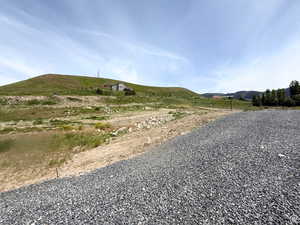 View of dirt / gravel road with a mountain view and a view of rural / pastoral area