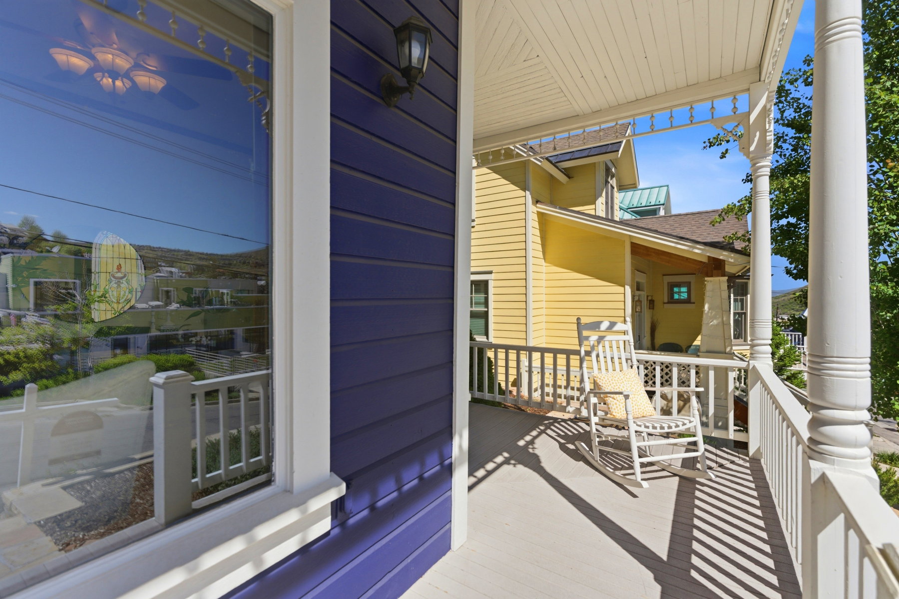 Front porch with white railings and a white-painted ceiling