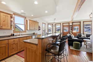 Kitchen with a kitchen breakfast bar, a center island, open shelves, decorative light fixtures, and beamed ceiling