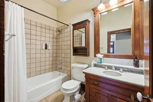 Full bathroom featuring shower / bath combo with shower curtain, vanity, and tile patterned floors