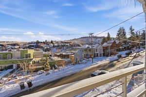 Snow covered back of property featuring a residential view