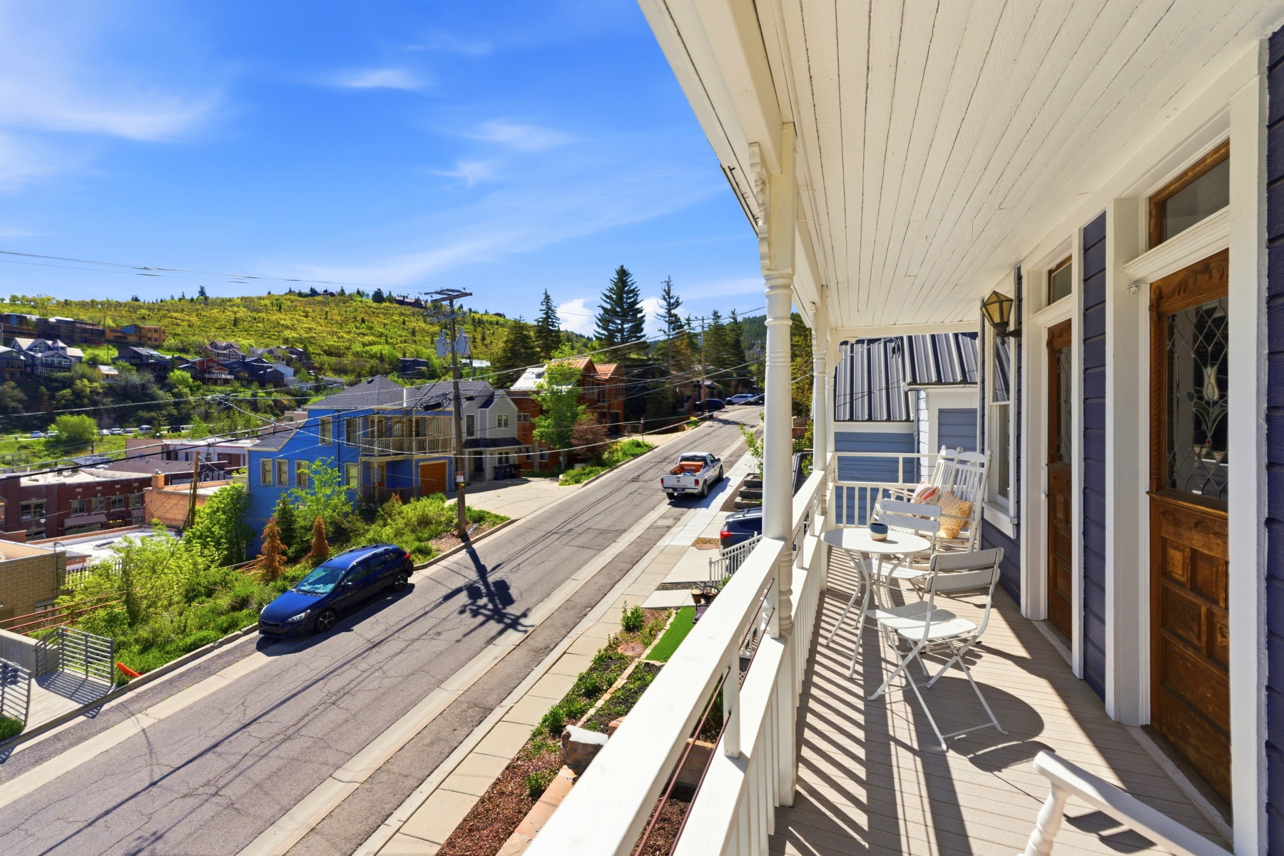 Covered porch featuring white railing and detailed columns