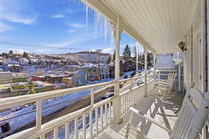 Snow covered back of property featuring a residential view