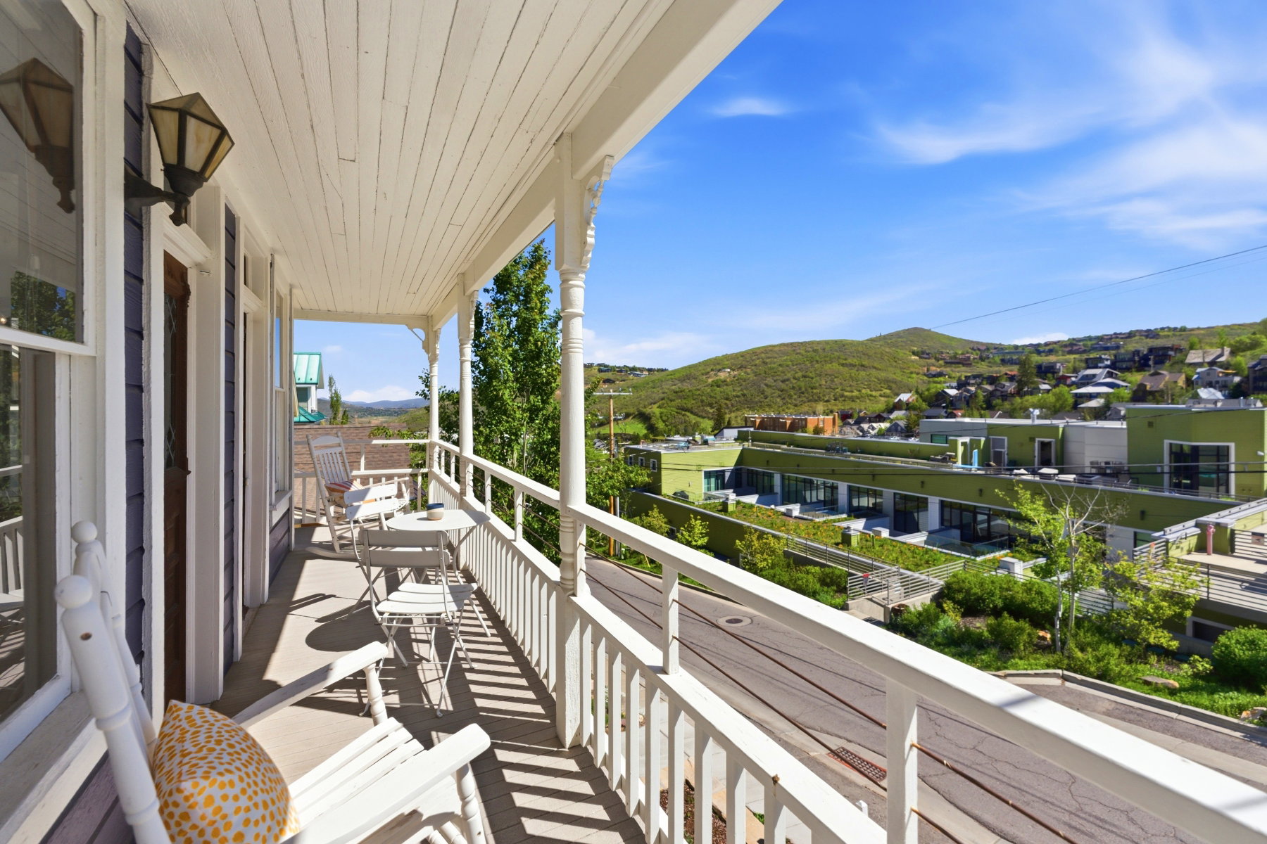 Covered balcony with white wood railing and beadboard ceiling