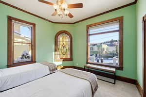 Bedroom featuring carpet flooring, ornamental molding, and ceiling fan