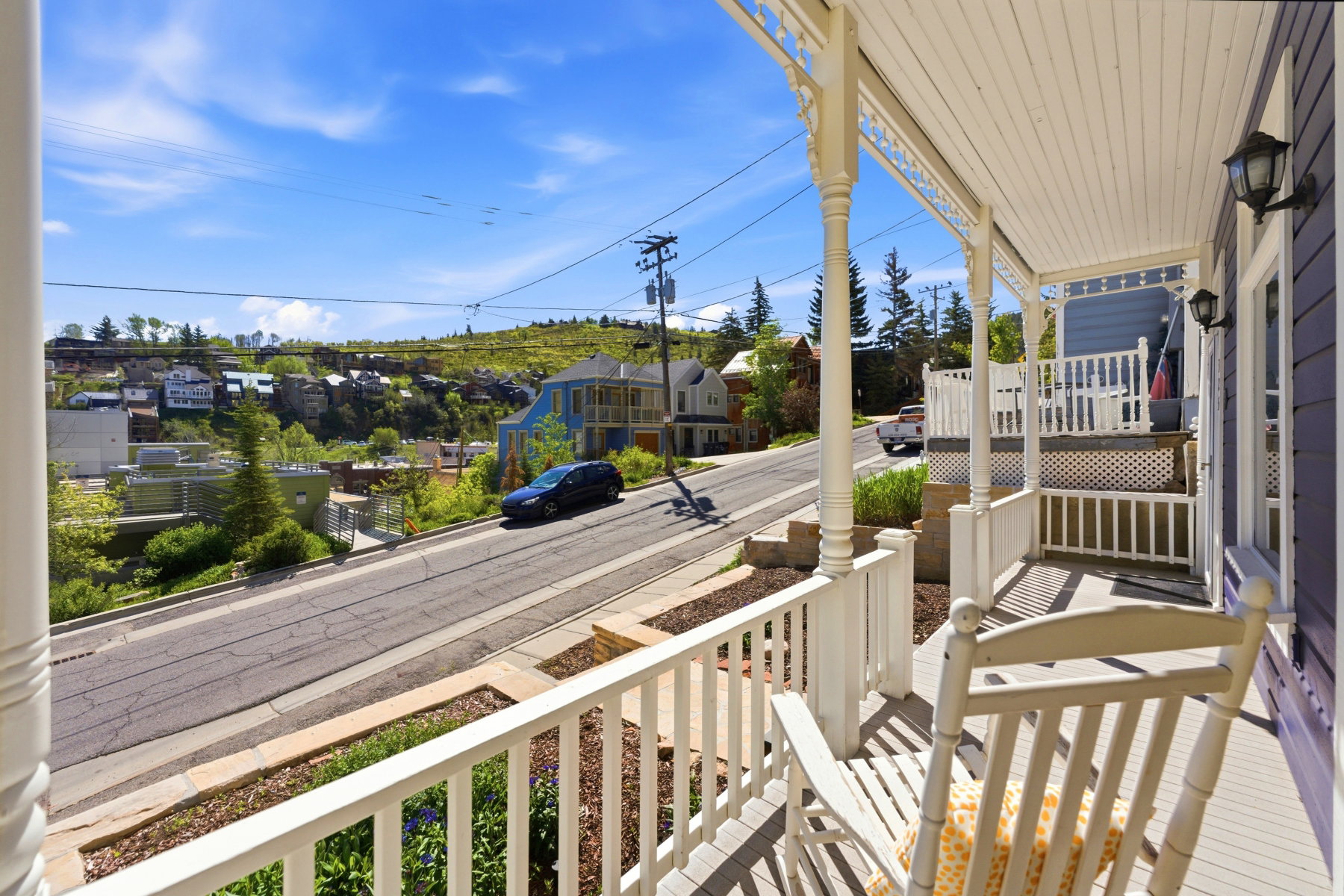 Covered front porch featuring decorative white balusters, turned columns, and a beadboard ceiling
