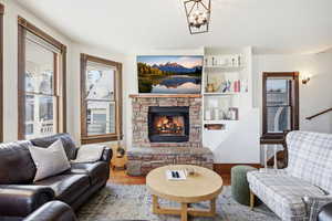 Living room featuring a stone fireplace and wood finished floors