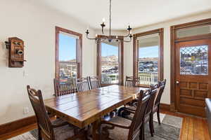 Dining room featuring wood-type flooring, healthy amount of natural light, and a chandelier