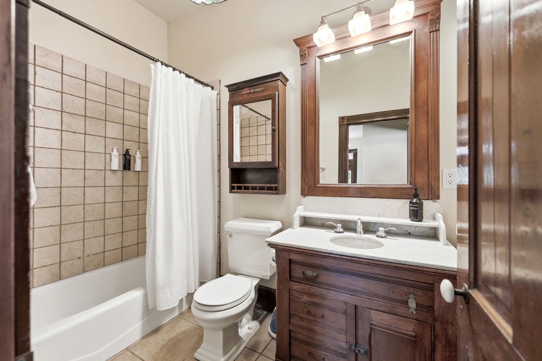 Bathroom featuring a wood vanity with an integrated sink and light-toned countertop