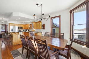Dining room with a chandelier, recessed lighting, dark wood finished floors, and plenty of natural light