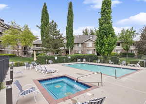 Community pool with a patio, a community hot tub, and a residential view