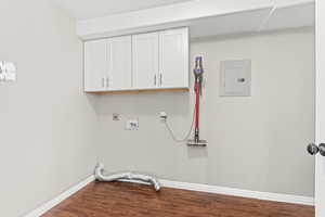 Laundry room featuring electric panel, dark wood-style flooring, cabinet space, washer hookup, and electric dryer hookup