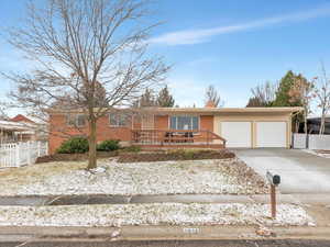 Single story home featuring concrete driveway, brick siding, and a garage