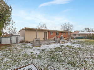 Snow covered property with a patio area and a gate
