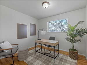Home office with baseboards and light wood finished floors