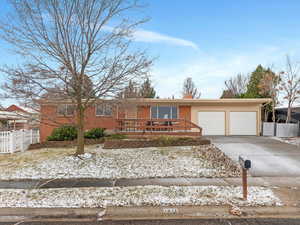 Single story home with driveway, brick siding, and a garage