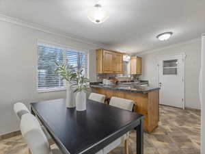 Dining space with crown molding and baseboards