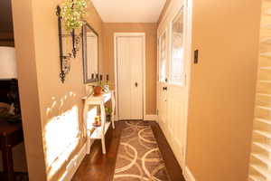 Doorway featuring baseboards and wood finished floors