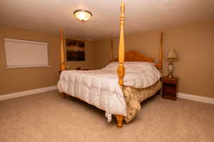 Bedroom featuring a textured ceiling and light carpet