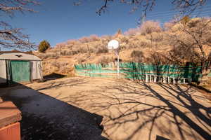 View of patio / terrace with a pool and a storage unit
