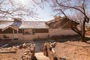 View of property exterior featuring a chimney and brick siding