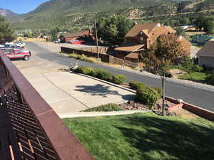 View of asphalt street featuring a mountain view, a residential view, curbs, and sidewalks
