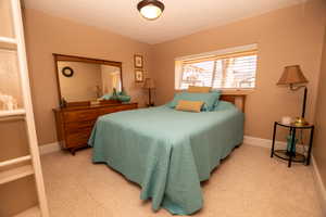Bedroom featuring a textured ceiling and baseboards