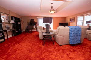Living room with carpet, a raised ceiling, and a textured ceiling
