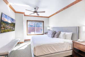 Carpeted bedroom featuring a ceiling fan, crown molding, and a textured wall