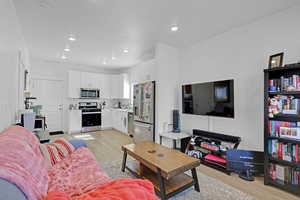 Living room with light wood finished floors and recessed lighting