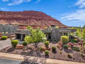 Pueblo-style house featuring stucco siding, a mountain view, and concrete driveway