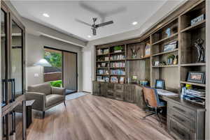 Home office with built in desk, light wood-style flooring, a ceiling fan, recessed lighting, and built in shelves