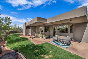 Back of property featuring stucco siding and a patio