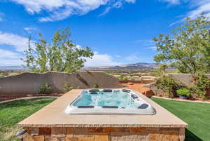 View of pool featuring an outdoor hot tub, a patio, a fenced backyard, and a mountain view