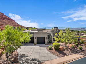 View of front of home with a mountain view, stucco siding, and driveway