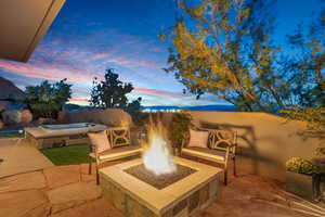 View of patio / terrace featuring an in-ground hot tub and an outdoor fire pit