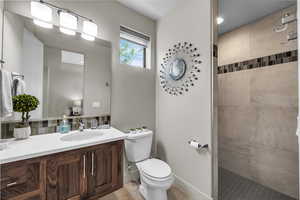 Bathroom with vanity, a walk in shower, light tile patterned floors, and backsplash